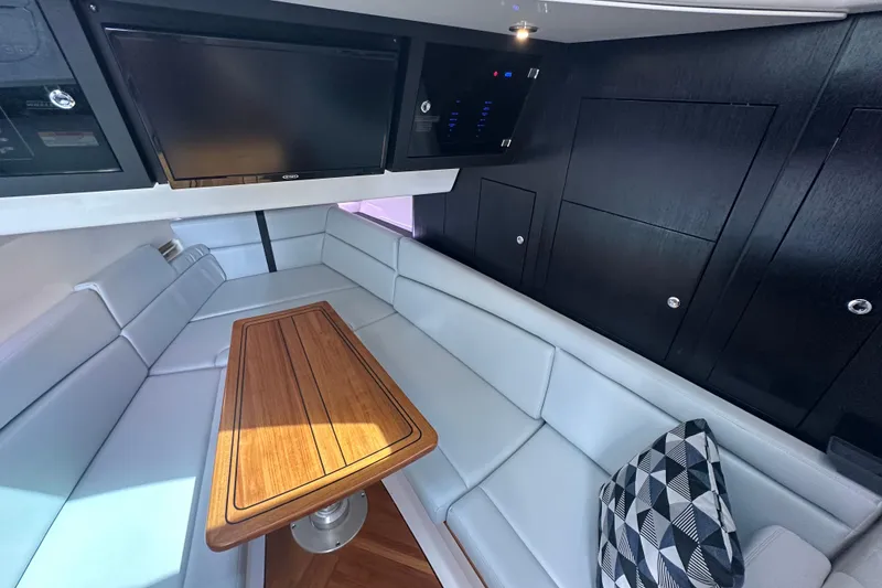 Slide: The Image of Luxurious interior of 2024 Boston Whaler 380 Realm with sleek seating and wooden table. - 16