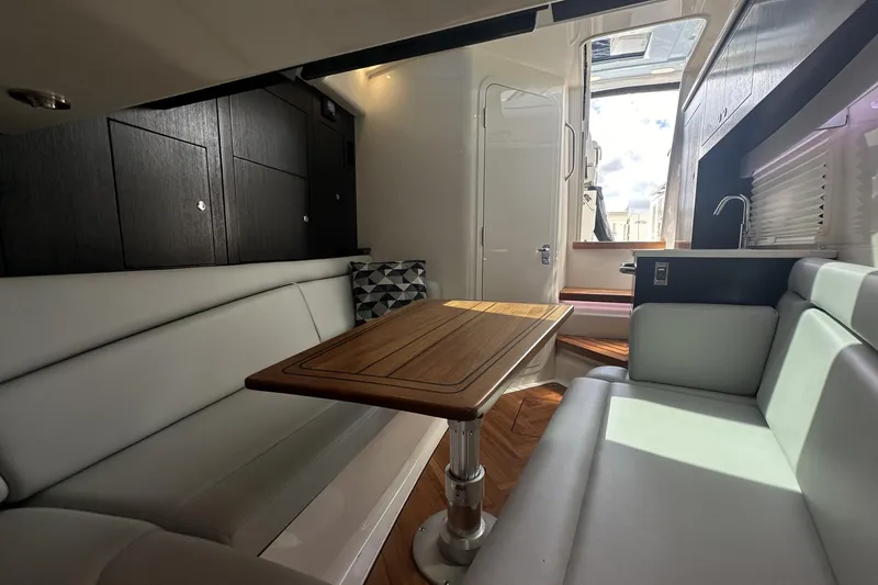 Slide: The Image of Luxurious interior of 2024 Boston Whaler 380 Realm with elegant seating and wooden table. - 17