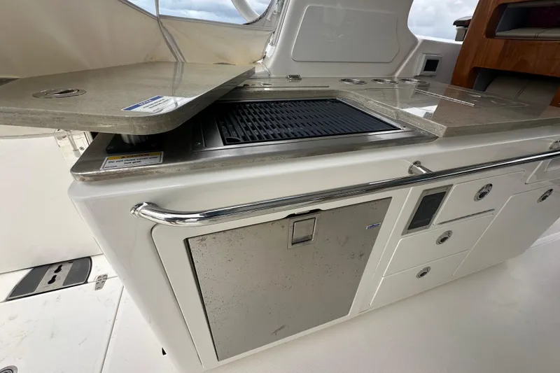 Slide: The Image of 2024 Boston Whaler 380 Realm boat kitchen with grill and storage compartments. - 20