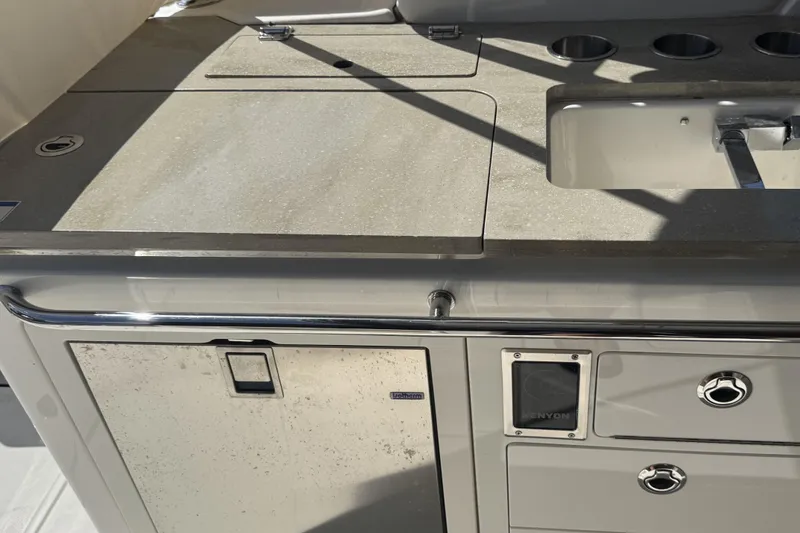 Slide: The Image of 2024 Boston Whaler 380 Realm boat kitchen area with sink and storage compartments. - 4