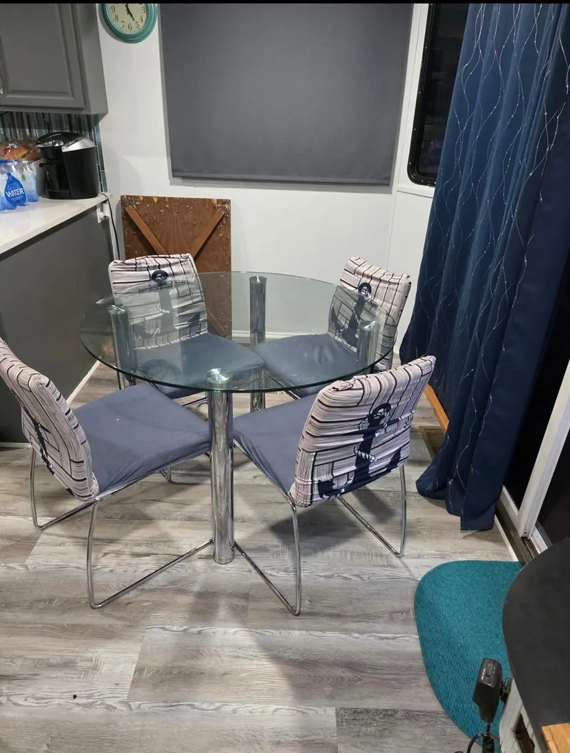 Slide: The Image of Round glass table with four chairs in modern dining area. - 5