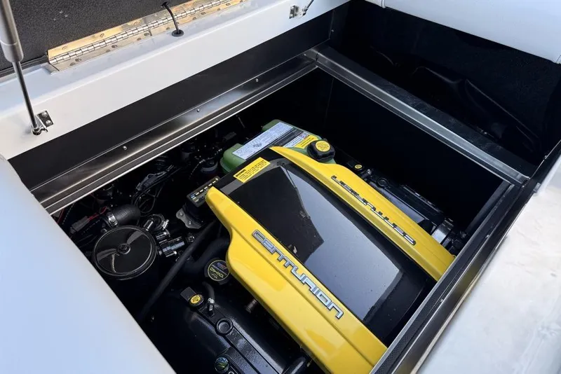 Slide: The Image of Engine compartment of 2026 Centurion Nv233 boat, featuring a yellow engine cover. - 14