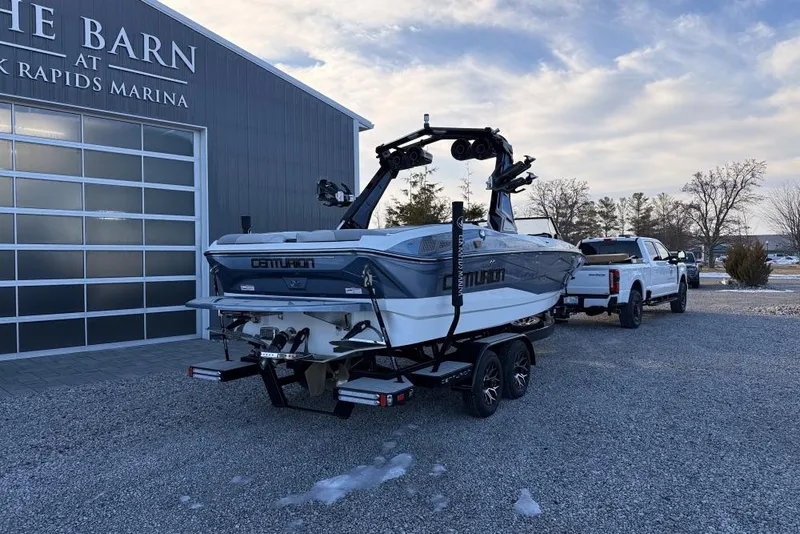 Slide: The Image of 2026 Centurion Nv233 boat on trailer at marina, clear sky background. - 3
