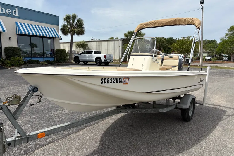 Slide: The Image of 2011 Scout 160 Sportfish boat on trailer, parked outside a building. - 7