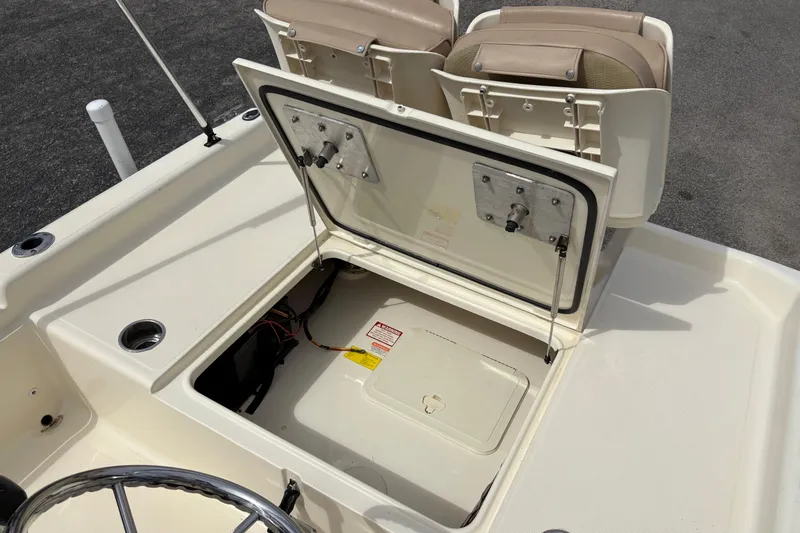 Slide: The Image of 2011 Scout 160 Sportfish boat storage compartment with open hatch and seating area. - 9