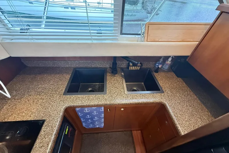 Slide: The Image of Kitchen area of 2001 Cruisers Yachts 4450 Express Motoryacht with dual sinks and granite countertops. - 13