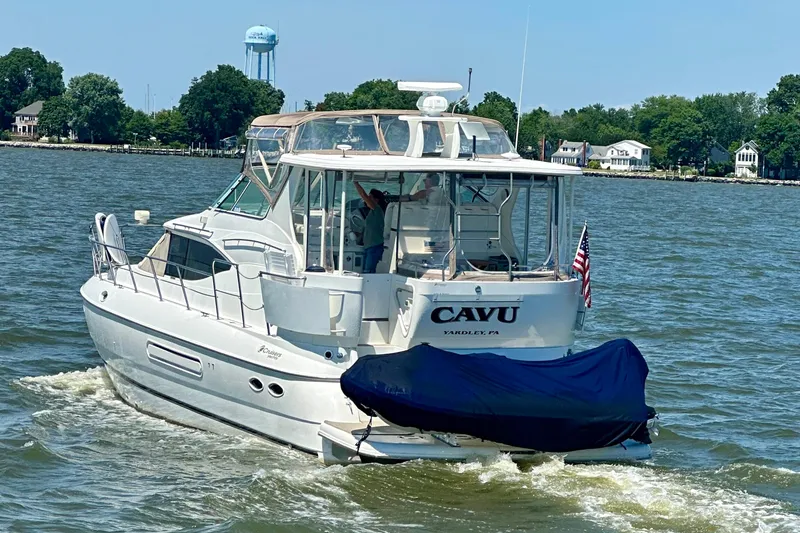 Slide: The Image of 2001 Cruisers Yachts 4450 Express Motoryacht cruising on a sunny day near shoreline. - 2