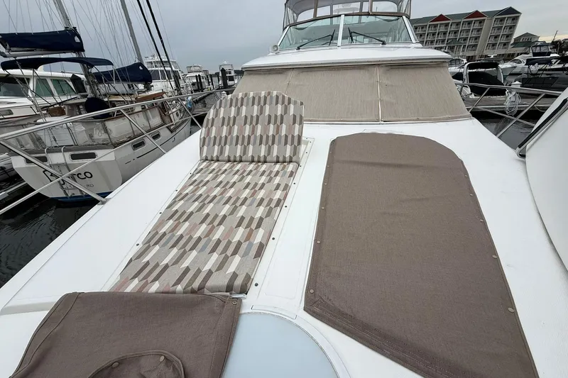 Slide: The Image of 2001 Cruisers Yachts 4450 Express Motoryacht with patterned sunbed on deck at marina. - 27