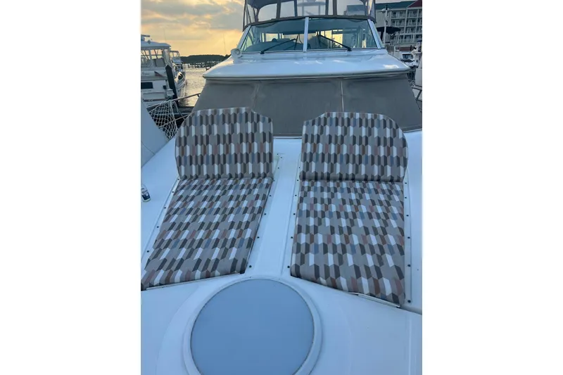Slide: The Image of 2001 Cruisers Yachts 4450 Express Motoryacht with patterned deck seating at sunset. - 28