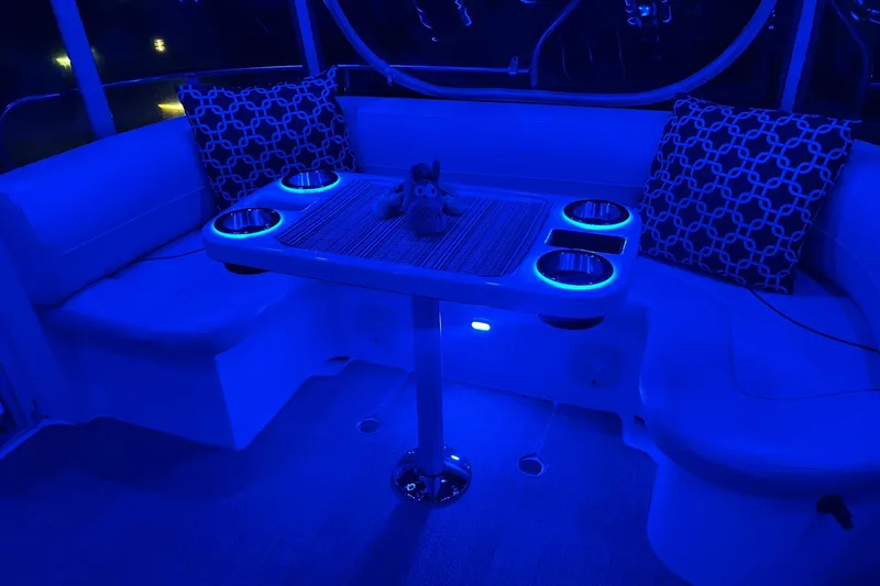 Slide: The Image of Luxurious 2001 Cruisers Yachts 4450 Express Motoryacht interior with blue LED lighting and seating area. - 4