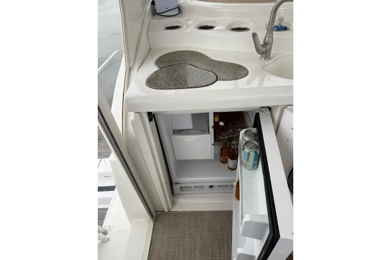 Slide: The Image of 2001 Cruisers Yachts 4450 Express Motoryacht kitchenette with open mini fridge and sink. - 9