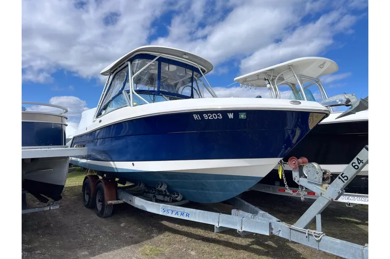 The Image of 2014 Robalo R247 Dual Console boat on trailer under blue sky. - 0