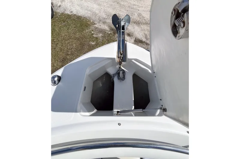 Slide: The Image of 2014 Robalo R247 Dual Console anchor compartment with open hatch, showcasing storage space. - 11