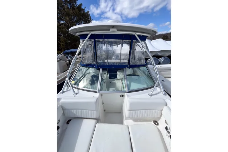 Slide: The Image of 2014 Robalo R247 Dual Console boat with blue canopy and white seating. - 15