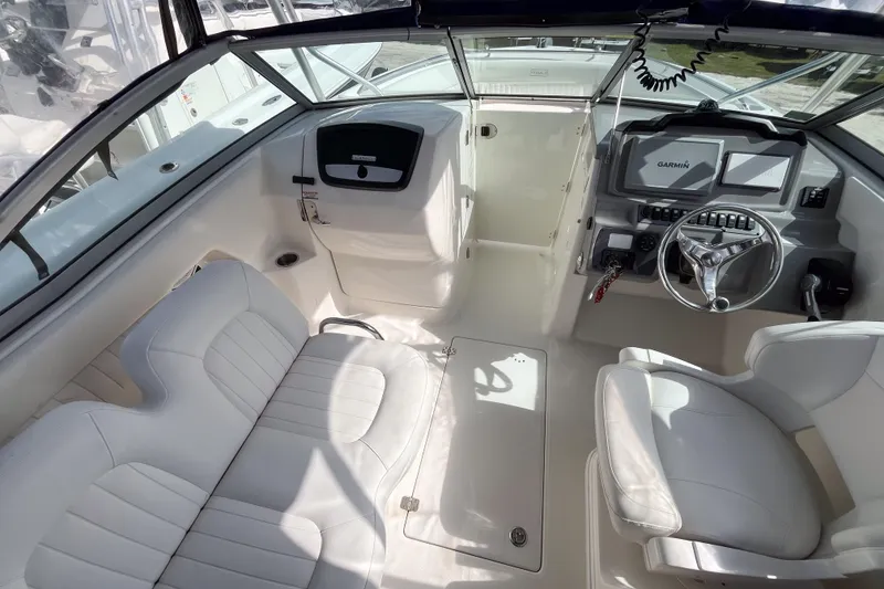 Slide: The Image of 2014 Robalo R247 Dual Console boat interior with white seating and Garmin navigation system. - 5