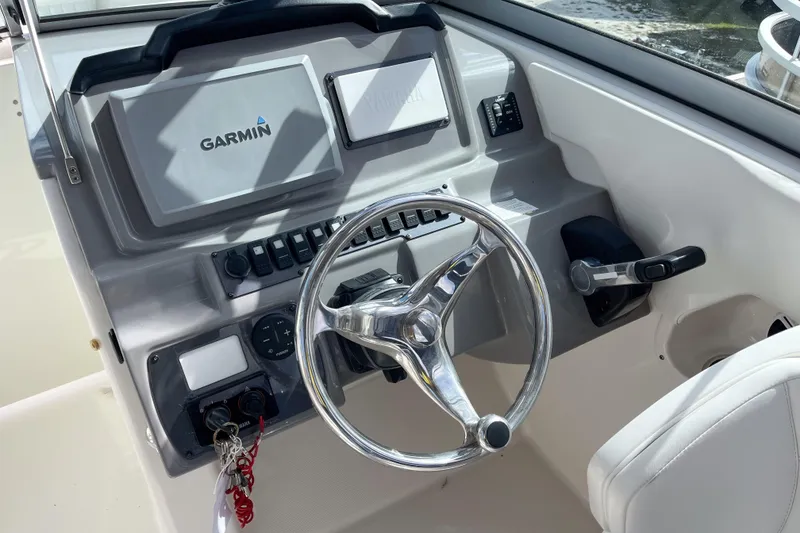 Slide: The Image of 2014 Robalo R247 Dual Console helm with Garmin navigation system and steering wheel. - 6