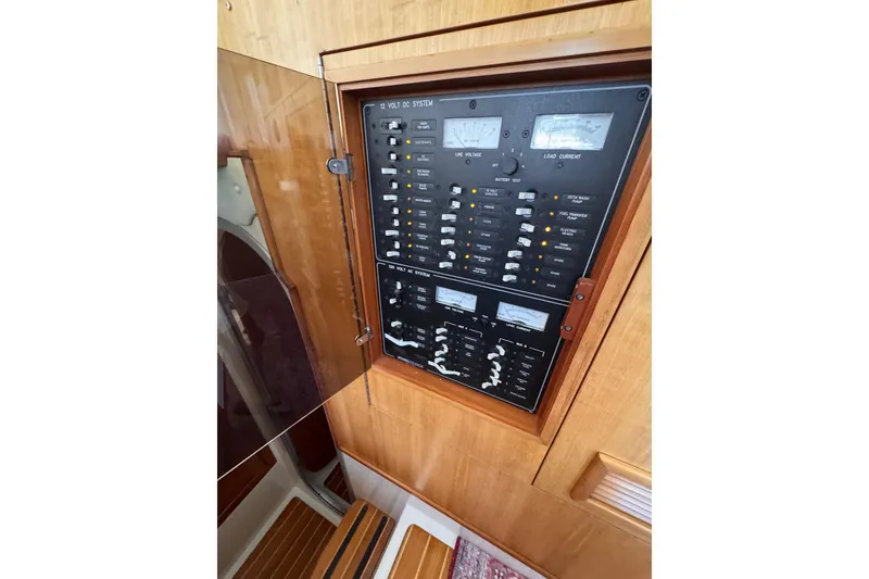 Slide: The Image of Electrical panel inside 2006 PDQ PowerCat boat, featuring various switches and gauges. - 16