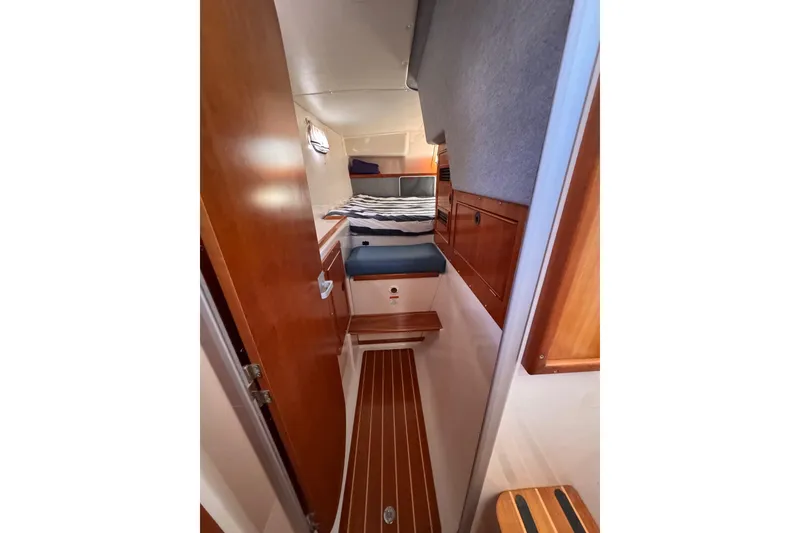 Slide: The Image of 2006 PDQ PowerCat cabin interior with wood paneling and cozy sleeping area. - 18