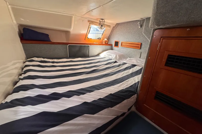 Slide: The Image of Cozy cabin interior of 2006 PDQ PowerCat with striped bedding and wooden accents. - 19