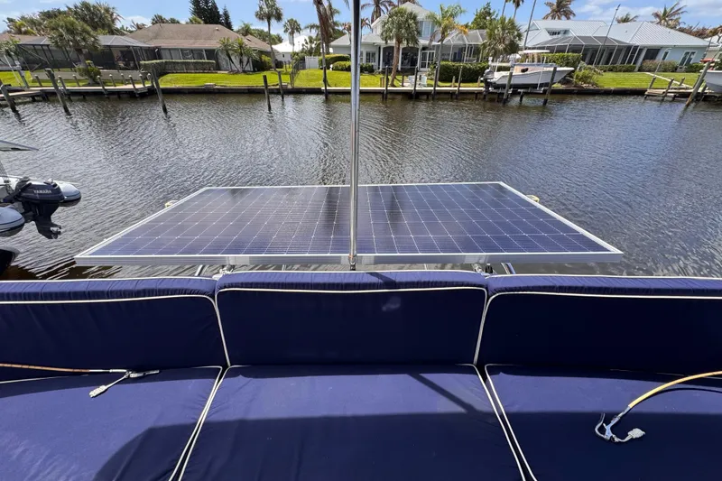 Slide: The Image of Solar panels on a 2006 PDQ PowerCat boat, docked by waterfront homes. - 23