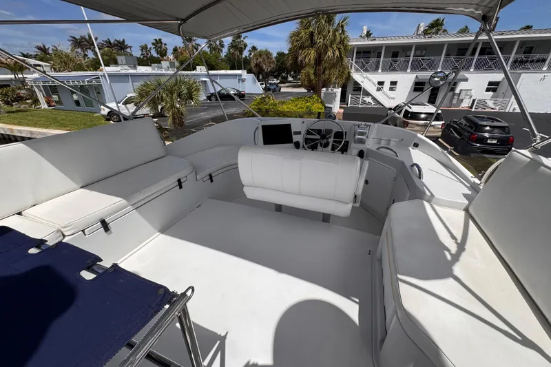 Slide: The Image of 2006 PDQ PowerCat boat interior with white seating and steering area under canopy. - 26