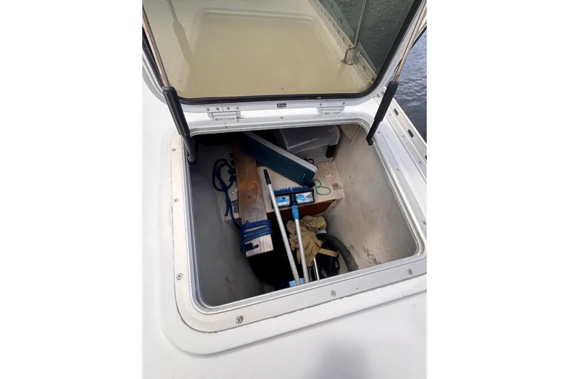 Slide: The Image of Open storage compartment on 2006 PDQ PowerCat boat with various equipment inside. - 28