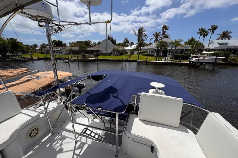 Slide: The Image of 2006 PDQ PowerCat boat docked by waterfront homes under a clear blue sky. - 29