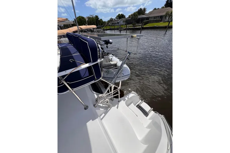 Slide: The Image of 2006 PDQ PowerCat boat docked by a serene waterfront with blue seating. - 30