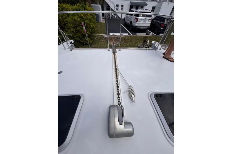 Slide: The Image of 2006 PDQ PowerCat deck with anchor chain and railing in a marina setting. - 31