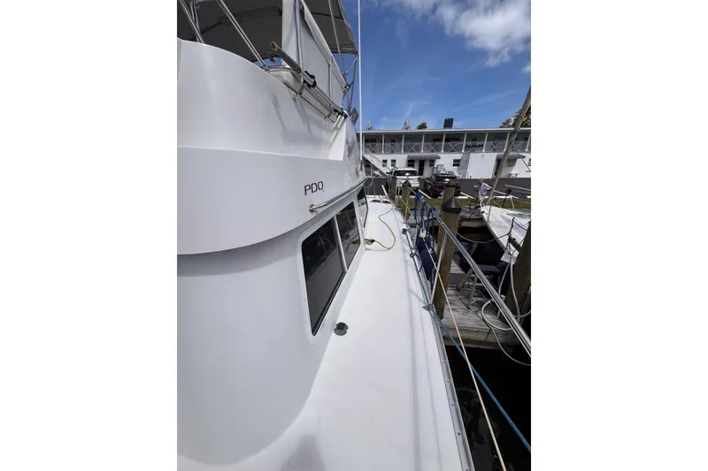 Slide: The Image of 2006 PDQ PowerCat boat docked at marina under clear blue sky. - 32
