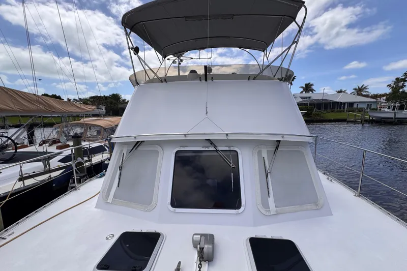 Slide: The Image of 2006 PDQ PowerCat boat docked, featuring a covered upper deck and sleek design. - 33