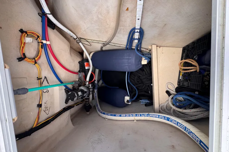 Slide: The Image of Interior view of a 2006 PDQ PowerCat boat showing wiring, ropes, and equipment storage. - 34