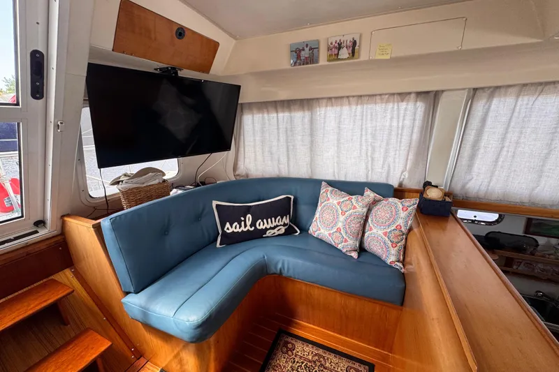 Slide: The Image of Cozy 2006 PDQ PowerCat interior with blue seating, decorative pillows, and a mounted TV. - 4