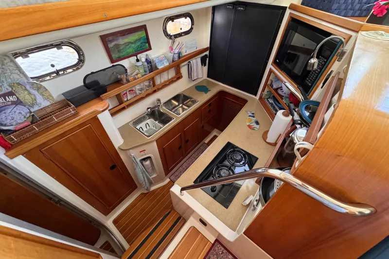 Slide: The Image of Compact kitchen in 2006 PDQ PowerCat boat with wooden cabinetry and modern appliances. - 5