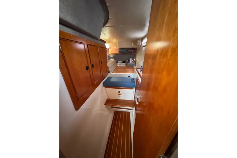 Slide: The Image of Interior of 2006 PDQ PowerCat boat with wooden cabinets and seating area. - 8
