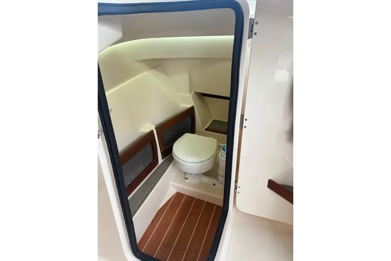 Slide: The Image of 2022 Grady-White Freedom 235 boat interior with compact marine toilet. - 15