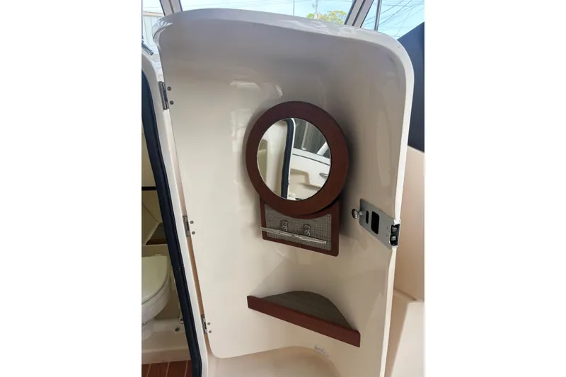 Slide: The Image of Interior of 2022 Grady-White Freedom 235 boat with mirror and storage shelf. - 16