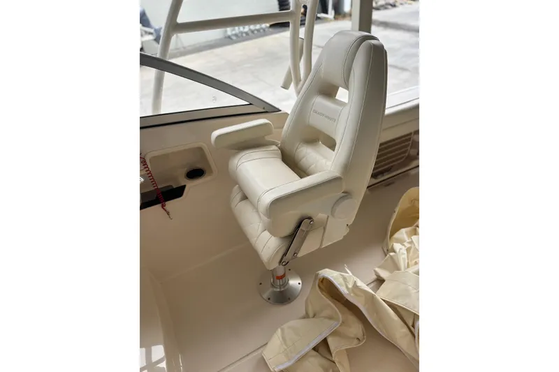 Slide: The Image of Captain's chair in 2022 Grady-White Freedom 235 boat, featuring plush white upholstery. - 19