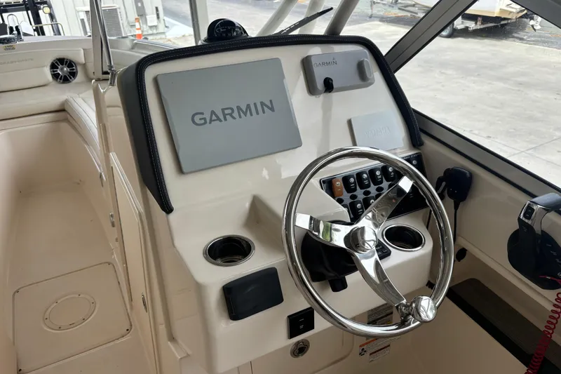 Slide: The Image of 2022 Grady-White Freedom 235 boat helm with Garmin navigation system and steering wheel. - 33