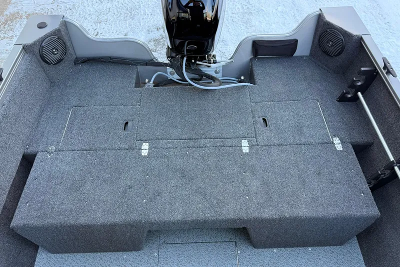 Slide: The Image of 2026 Crestliner 1650 Kodiak boat interior with carpeted deck and motor. - 17