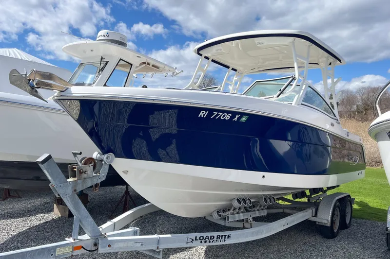 The Image of 2020 Robalo R247 Dual Console boat on trailer under blue sky. - 0