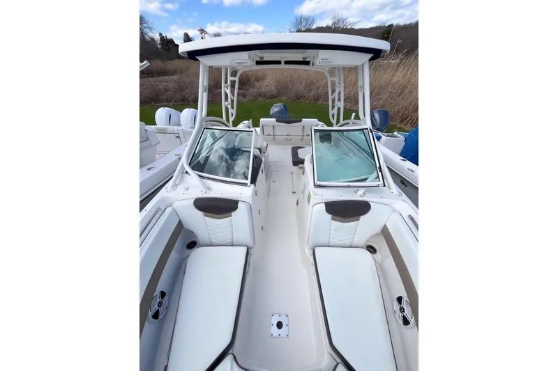 Slide: The Image of 2020 Robalo R247 Dual Console boat interior with white seating and open windshield. - 13