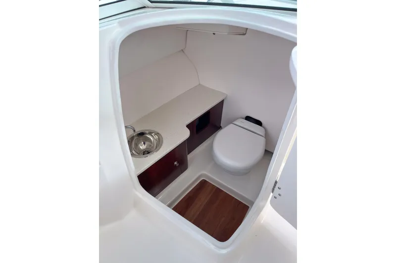 Slide: The Image of 2020 Robalo R247 Dual Console boat interior with compact bathroom and sink. - 7