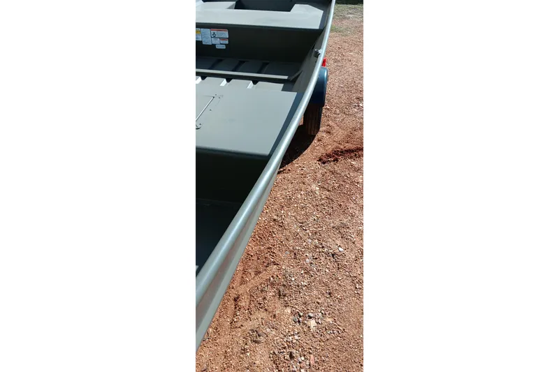 Slide: The Image of 2026 Tracker Topper 1542 LW Riveted Jon boat on gravel surface. - 14
