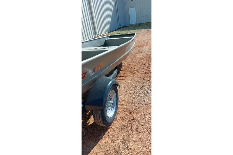Slide: The Image of 2026 Tracker Topper 1542 LW Riveted Jon boat on trailer, parked on gravel. - 5