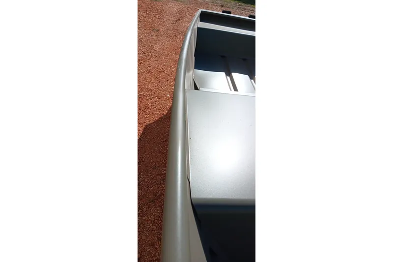 Slide: The Image of 2026 Tracker Topper 1542 LW Riveted Jon boat on gravel surface, side view. - 8