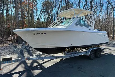 The Image of 2022 Sailfish 245 DC boat on trailer in wooded area. - 0