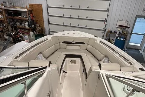 Slide: The Image of 2022 Sailfish 245 DC boat interior with spacious seating in a garage setting. - 11