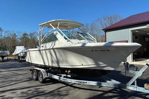 Slide: The Image of 2022 Sailfish 245 DC boat on trailer, parked outdoors near a building. - 5