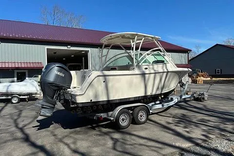 Slide: The Image of 2022 Sailfish 245 DC boat on trailer, parked outside a large building. - 6